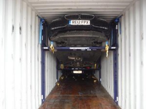bmw suspended on car racking inside container